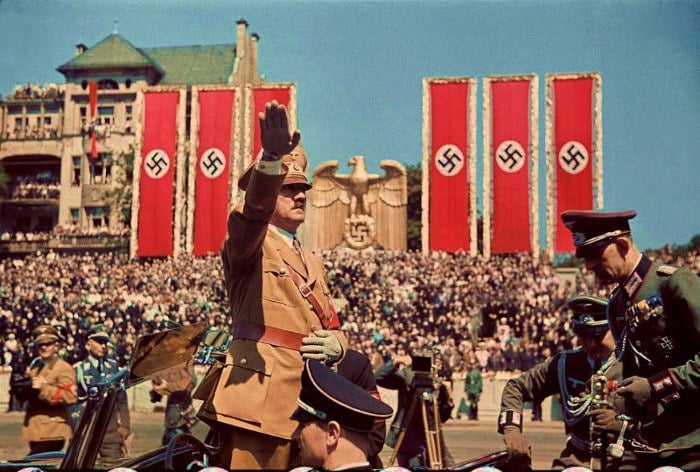 Hitler saluting with swastikas on the back